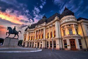 Historic Romanian university building illuminated at dusk