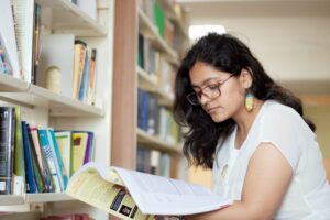 a student reading book in a library