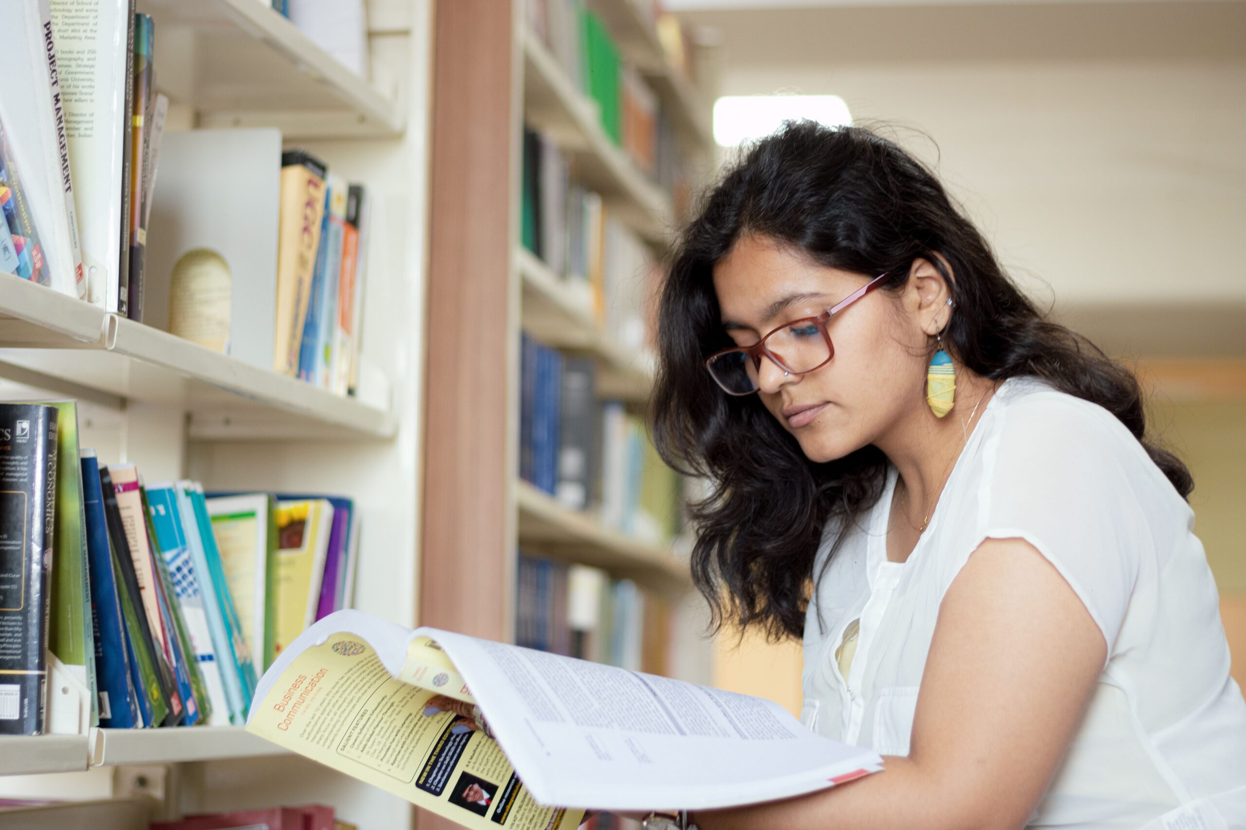 a student reading book in a library